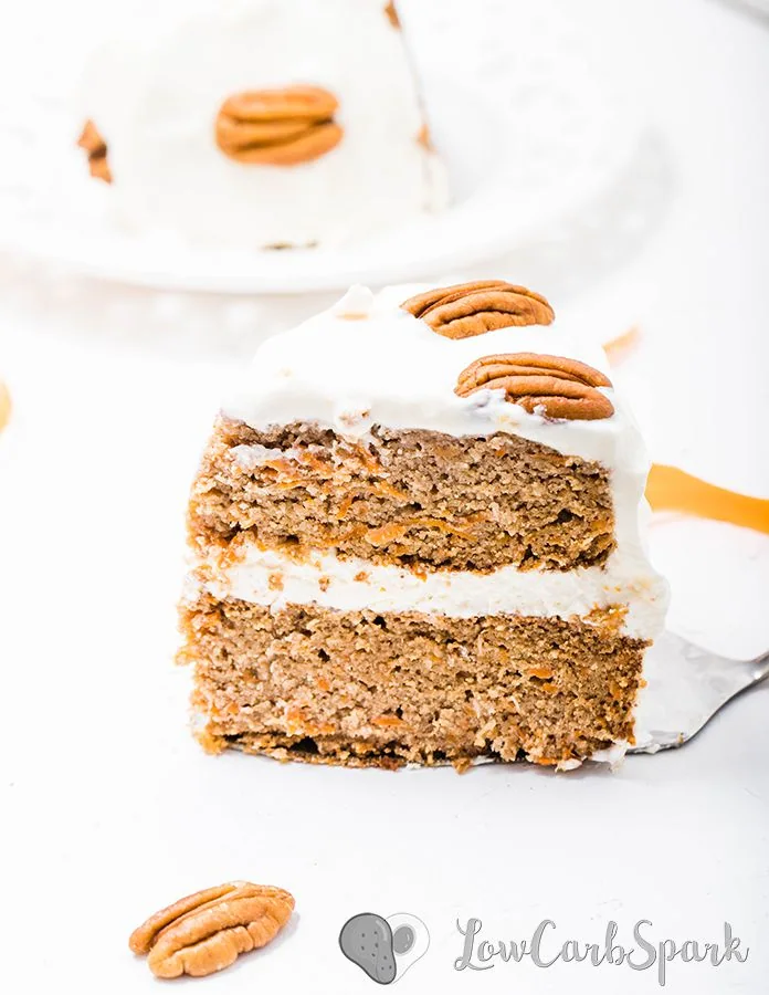 a keto carrot cake slice with sugar-free cream cheese frosting and pecans
