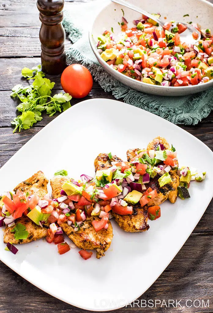 lime chicken with avocado salsa on a white plate