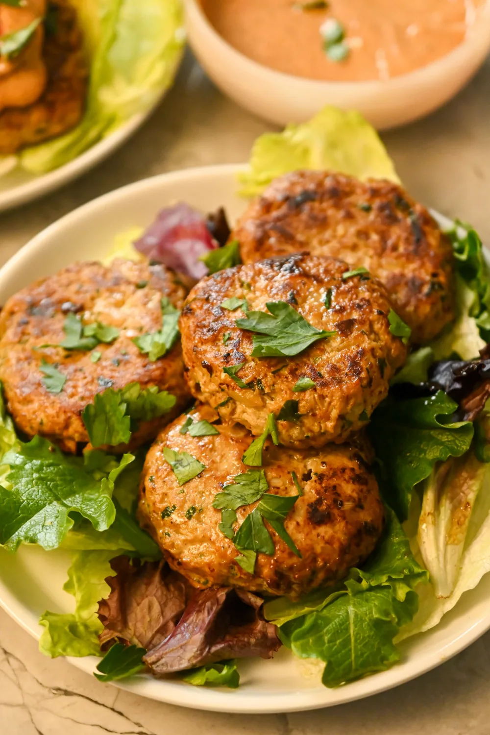 keto ground chicken burgers stacked on a bed of greens.jpg